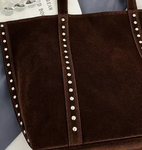 Detailaufnahme der dunkelbraunen Wildleder-Tote Bag mit silbernen Metallnieten-Verzierungen