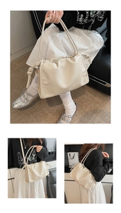 Close-up of cream soft PU leather cloud bag with ruched design and knotted shoulder strap
