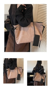 Détail du sac cabas en daim avec texte gaufré et mini pochette noire attachée