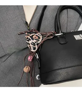 Détail du charme coeur léopard avec pompon sur accessoire de sac à main bowling noir