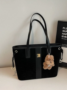 Large black suede tote bag with leather handles and a brown plush bear charm
