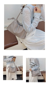 Detail view of grey pleated cloud bag with stylish knotted shoulder strap accents