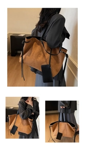 Détail du sac cabas en daim marron avec texte embossé et pochette amovible en cuir noir