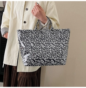 Detail of large black and white leopard print tote bag with white TOTE BAG text print