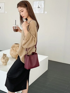 Minimalist burgundy litchi grain leather bucket bag with top handle and shoulder strap