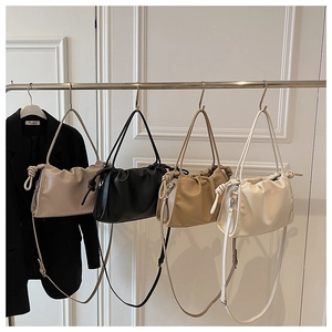 Row of pleated cloud bags in beige, black, khaki and cream with long shoulder straps