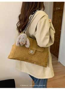 Nahaufnahme braune gesteppte Wildledertasche mit Kettenriemen und Plüschhasenanhänger
