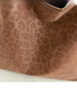 Close-up of soft matte leopard print fabric texture on a large capacity tote bag