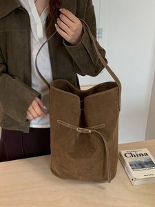 Sac seau vintage en daim marron avec poignée supérieure et détail de sangle épuré