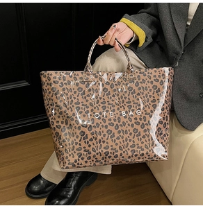 Detail shot of leopard print tote bag with white TOTE BAG text and glossy finish