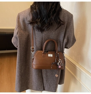 Détail du sac Boston marron rétro avec breloque cœur léopard et fermoir argenté tournant