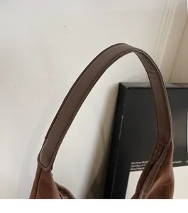 Detailed close-up of comfortable smooth brown leather shoulder strap with fine stitching