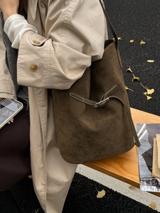 Sac seau en daim marron foncé mat avec surpiqûres contrastées et boucle argentée