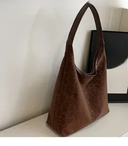 Detail shot of a brown leopard print hobo bag with suede texture and a large interior