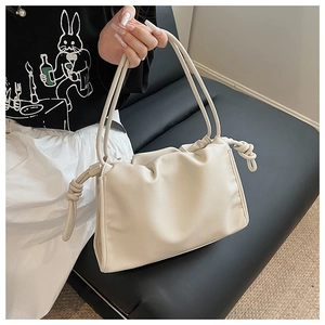 Close-up of beige pleated cloud bag with soft textured faux leather and knot details