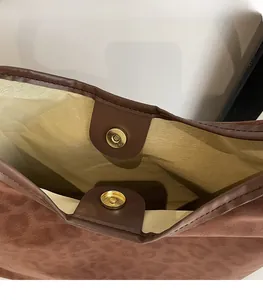 Macro detail of the magnetic snap closure on a matte leopard print tote bag interior