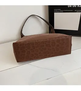 Close-up of the leopard print pattern and matte suede texture on a brown tote bag