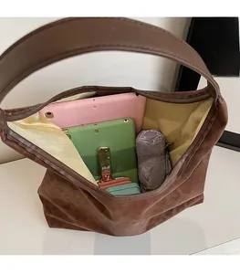 Spacious interior of dark brown suede tote bag holding tablet and daily essentials