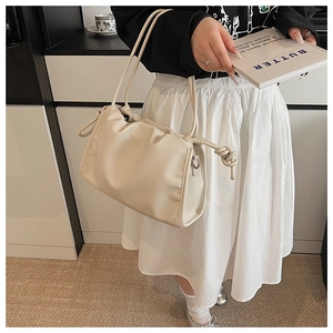 Detail of soft pleated cloud bag in beige with knot decor and slim double straps