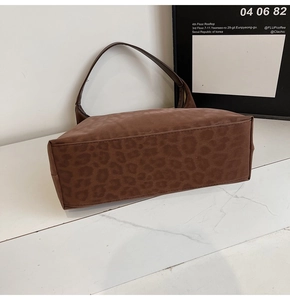 Detail of wide flat base and stitching on a large leopard print tote shoulder bag