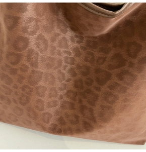 Close-up of matte leopard print fabric and neat leather trim on the large tote bag