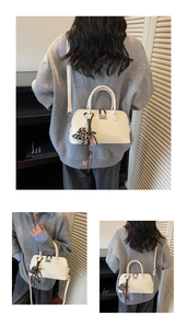 Détail d'un sac bowling en cuir crème avec charm cœur en peluche à motif léopard