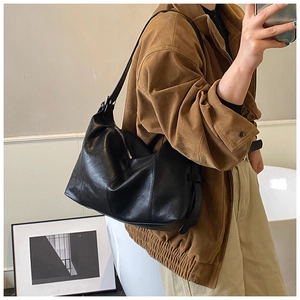 Mirror selfie showing the medium black soft leather shoulder bag with drape and side straps