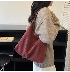 Close-up of a burgundy leopard print hobo bag with a textured matte finish and large capacity