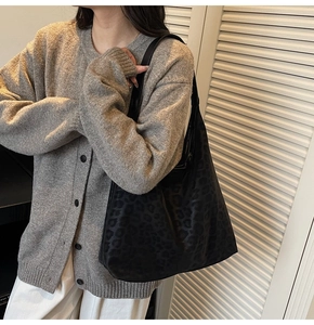 Close-up of leopard print hobo bag worn by model showing large capacity and matte texture