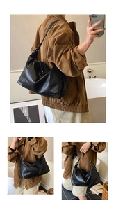 Detail view of large black hobo shoulder bag with soft pleated faux leather texture