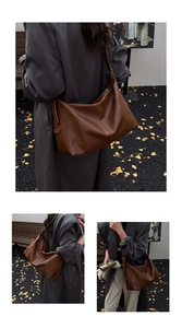 Detailed close-up showing soft matte leather texture and stitching of a dark brown tote