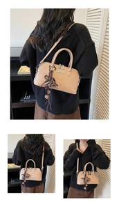 Détail du sac bowling beige en cuir avec nœud léopard et bandoulière amovible