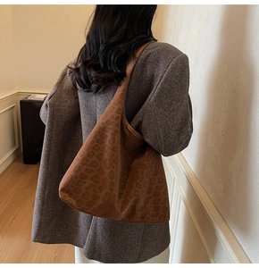 Deep brown leopard print tote bag with suede texture shown in a casual shoulder wear style