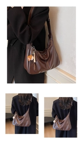 Détail du sac hobo en cuir marron foncé avec surpiqûres blanches et charme sportif