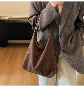 Brown leopard print suede hobo bag styled on model with grey wool blazer and beige pants
