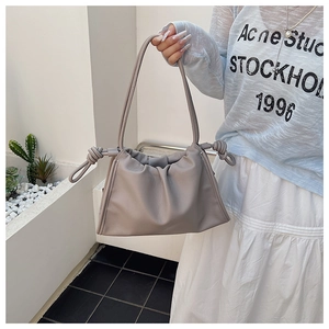 Detail of grey pleated cloud bag with soft leather finish and knotted handle detail