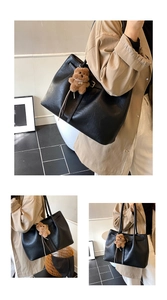 Detail of black faux leather tote with litchi texture and brown teddy bear charm