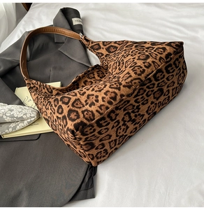 Detailed close-up of leopard print canvas tote bag with premium leather handles and silver hardware