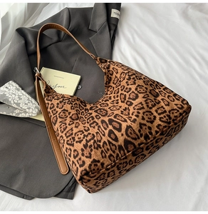 Detail of leopard print tote bag on white fabric with fashion accessories for daily use