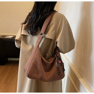 Detailed texture of brown quilted crescent tote bag with soft pleated fabric and shoulder strap
