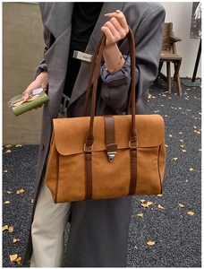 Dettaglio borsa tote in pelle scamosciata marrone vintage con cinturini in metallo