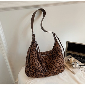 Detailed close-up of leopard print hobo bag with adjustable brown leather shoulder strap