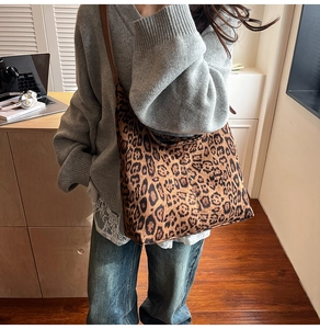Detail shot of leopard print tote bag with brown strap on a casual grey knit outfit