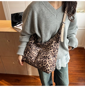 Detail of leopard print tote bag with adjustable beige leather strap and fabric texture