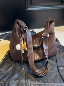 Grand sac seau marron foncé avec surpiqûres blanches et pendentif baseball sur cuir