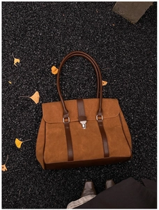 Dettaglio borsa tote in pelle scamosciata marrone con cinturini in pelle e chiusura argento