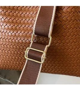 Dettaglio della borsa in pelle intrecciata marrone scuro con tracolla regolabile in nylon