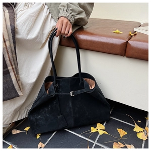 Detail of black matte tote bag with silver buckle on autumn street background