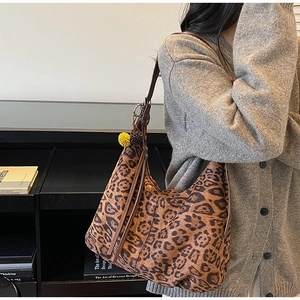 Detailed view of vintage leopard print tote bag with soft leather texture and tassel charm