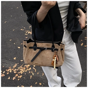 Detail der Vintage-Wildledertasche mit Lederbesatz und böhmischem Perlenanhänger